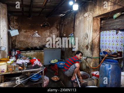 Bangladeshi man cooking in a restaurant kitchen in Korail slum, Dhaka Division, Dhaka, Bangladesh Stock Photo