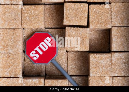 Stop sign on background of brown sugar cubes. Concept of stopping sugar production Stock Photo