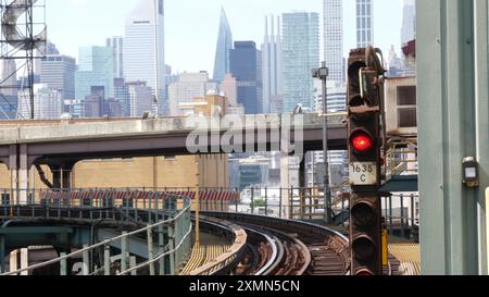 New York elevated subway, metropolitan bridge, metro track above street. Railway transport over road. Old railroad line. Queensboro station Manhattan skyline. Queens, Long Island city, United States. Stock Photo