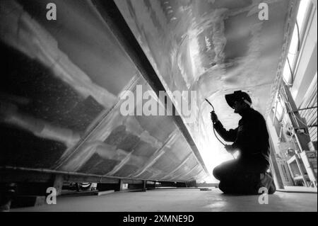 A welder working on the aluminium hull of a high speed launch, part of a fleet of 30 river taxis for the RIver Thames.   The launches were being built at Griffon Hovercraft in Netley Marsh, Hampshire and they began the water taxi service between Gravesend in Kent and the City of London.    20 May 1992    Picture by Roger Bamber Stock Photo