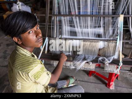 Young bangladeshi man working in a extile factory looms, Dhaka Division, Rupganj, Bangladesh Stock Photo