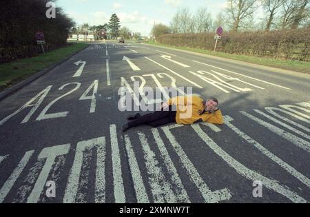 Dutch author Pieter Boogaart lies on the A272 at its junction with the A24 at Dragons Green near Billingshurst West Sussex . The road is the subject of 5 years work in writing a book A272 An Ode to a Road which has just been published7 March 2000 Picture by Roger Bamber Stock Photo