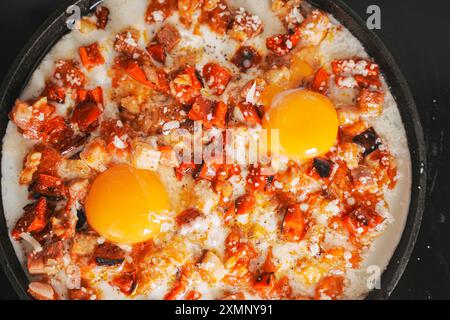 Scrambled eggs with vegetables or Shashuka in a cast-iron pan. Delicious and healthy breakfast. A traditional Jewish dish. Close-up. High quality phot Stock Photo