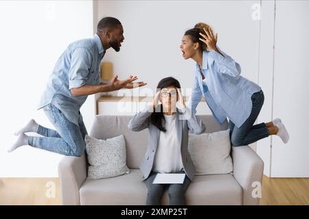 Shocked Marriage Counselor Watching Her Afro Patients Quarrelling In Office Stock Photo