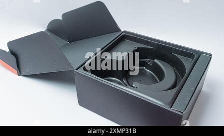 Opened black headset packaging box isolated on black background Stock Photo