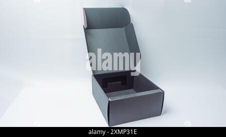 Opened black headset packaging box isolated on black background Stock Photo