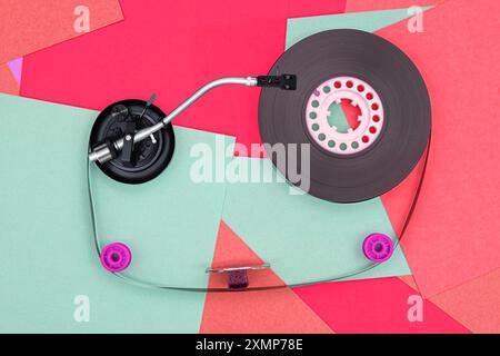 Top view of turntable arm on old vintage retro audio tape cassettes with a background of multicolored paper sticky notes Stock Photo