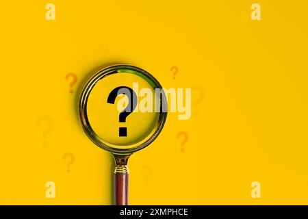 International ask a question day concept. Q&A, Communication and Brainstorming. Top view of magnifying glass and question mark isolated on yellow back Stock Photo