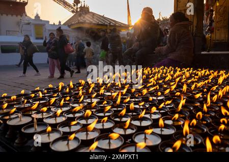 Prayer candles flicker outdoors as worshipers walk around the Boudhanath Stupa, Kathmandu, Nepal Stock Photo