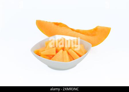 Slices of a melon in a white bowl isolated on white background. Stock Photo