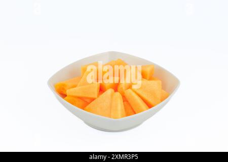 Slices of a melon in a white bowl isolated on white background. Stock Photo