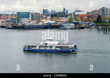 Vancouver, BC, Canada - April 25, 2024: A SeaBus passenger ferry boat arriving at Vancouver Harbour in Downtown Vancouver, British Columbia, Canada. Stock Photo