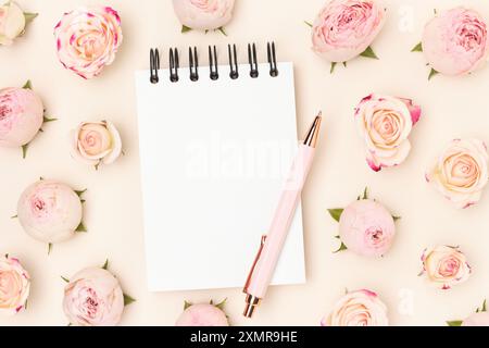 Clean notepad mockup. Stationery and pink rose flowers on a beige background. Stock Photo