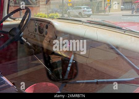 Route 66 decal grace dashboard of 1960 flatbed Ford seen through truck window reflections —  Winslow Arizona, April 2024 Stock Photo