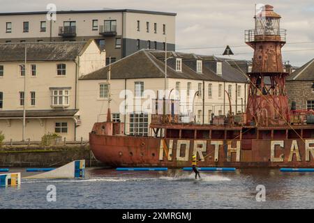 Waterskier in front of the historic lightship North Carr in the Victoria Dock in Dundee, UK, United Kingdom; the last remaining Scottish lightvessel Stock Photo