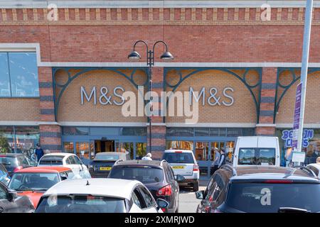 Front entrance of a Marks and Spencer store on a retail park with cars parked outside in front of the store. Stock Photo