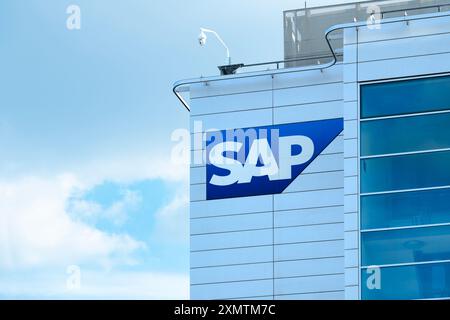 SAP SE logo prominently displayed on modern corporate headquarters facade, SAP corporate campus, symbolizing global software industry leadership, Wall Stock Photo
