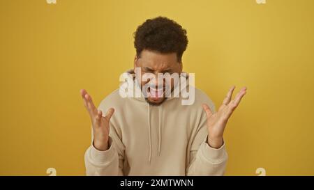 Shouting african american man with a handsome facial expression isolated against a yellow background. Stock Photo
