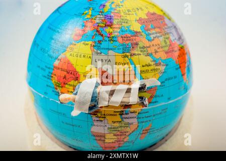 Tiny figurine of man  model wrapped in bandages  on earth Stock Photo