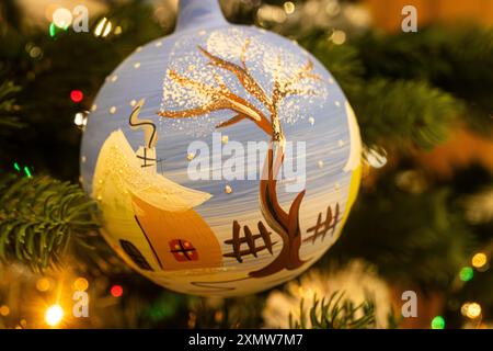 Close up of a painted Christmas bauble hanging on the Christmas tree. Winter scene painted on a Christmas ball. Blue Christmas decoration Stock Photo