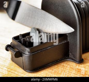 Sharpening of knife in a kitchen Stock Photo