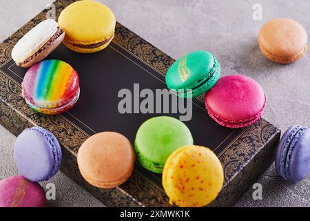 Variety of colorful macarons placed on an elegant decorative box, showcasing different flavors and vibrant colors. Stock Photo