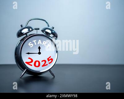 Start text and 2025 on white alarm clock on black table with copy space for preparation of Merry Christmas and Happy new year concept. Start new busin Stock Photo