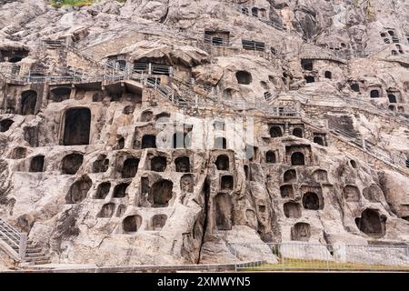 Longmen Grottoes hillside, which contains hundreds of caves with carved Buddha statues, Luoyang, China Stock Photo