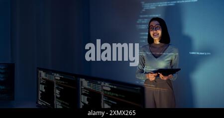 asian woman programmer standing in front of a screen with code projected  presentation the integration of technology and human expertise in software d Stock Photo