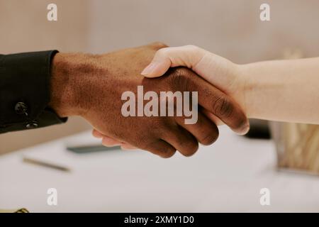 Closeup of hands of unrecognizable biracial man and woman doing handshake at work in office Stock Photo