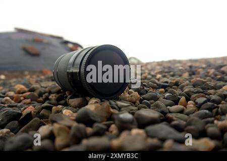 Resting peacefully on the ground, the camera lens symbolizes the power of perspective and the art of seeing things differently. It serves as a reminde Stock Photo