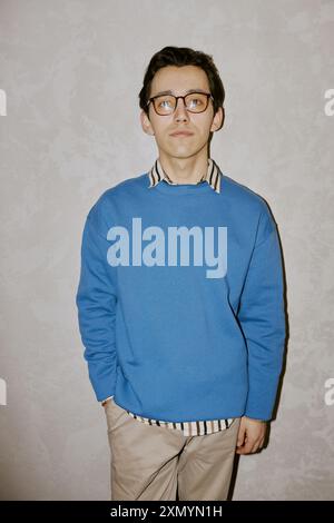 Vertical medium long shot of young biracial man wearing smart casual clothes with eyeglasses posing for camera Stock Photo