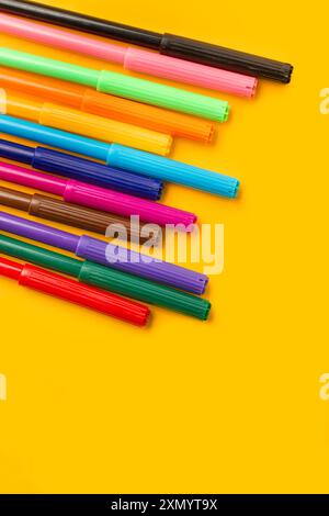 Colored markers on a yellow background with copy space Stock Photo