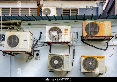 Old, weathered air conditioning units on the exterior wall of a building in Penang, Malaysia Stock Photo