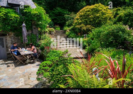 Two visitors enjoying food and drink at the tea room in Docton Mill Garden, Lymebridge, North Devon, England, UK Stock Photo