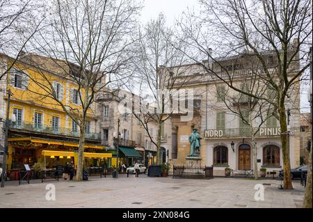 Arles, France - March 3, 2023: Statue Frederic Mistral and Le Cafe Van Gogh on Place du Forum on a cloudy day in springtime Stock Photo