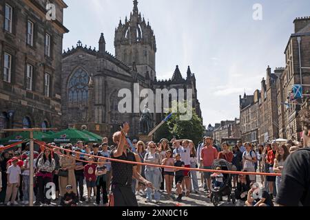 Edinburgh, city centre, Scotland, UK. 30 July 2024.  Summer in the city as the temperature reaches 21 degrees centigrade with a warm breeze for the tourists and residents out in Princes Street and the Royal Mile. Picturd: Super Scott local street performer entertains a sizeable crowd in the lead up to the the Edinburgh Festival Fringe which officially begins on Friday. Credit: Arch White/alamy live news. Stock Photo