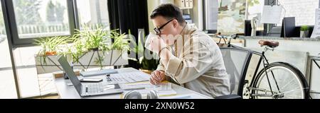 A young man with Down syndrome takes a break from his work, enjoying a cup of coffee. Stock Photo