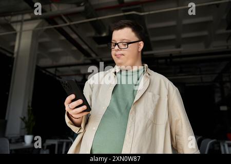 A man with Down syndrome smiles while using his phone. Stock Photo
