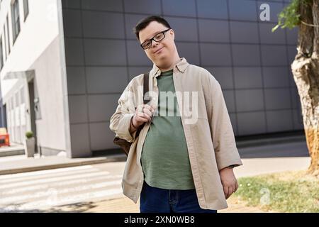 A man with Down syndrome walks down the street, smiling and carrying a bag. Stock Photo