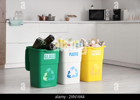 Full trash bins with different types of garbage near brick wall ...