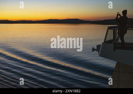 A woman taking a photo on the ferry from Friday Harbor in Washington State. Stock Photo