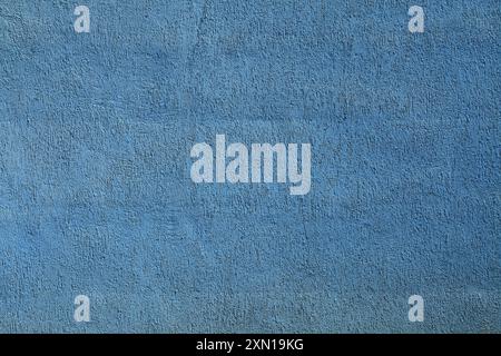 Very worn blue wall, texture, background. Decor of pale bright-blue textured coating. Structural plaster, rough, uneven surface in blue color Stock Photo