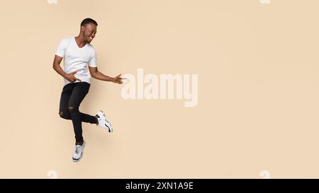 Guy Pointing Fingers Aside Having Fun Over Yellow Background, Panorama Stock Photo