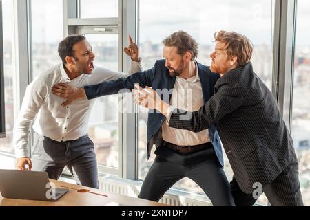 Three Businessmen Involved in Intense Argument in a Modern Office Stock Photo
