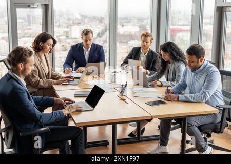 Diverse Team Working on Laptops in Modern Office Setting Stock Photo