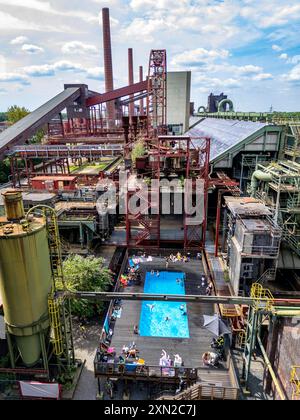 Das Werksschwimmbad auf der Kokerei Zollverein, immer während der NRW Sommerferien in Betrieb, ehemaliges Kunstobjekt, jetzt Badespaß vor der Kulisse der einst größten Zentralkokerei Europas, 1993 geschlossen, Teil des UNESC Welterbe Zeche Zollverein, Essen, NRW, Deutschland Werksschwimmbad Zollverein *** The works swimming pool at the Zollverein coking plant, always in operation during the NRW summer vacations, former art object, now swimming fun against the backdrop of what was once Europes largest central coking plant, closed in 1993, part of the UNESC World Heritage Zollverein Coal Mine In Stock Photo