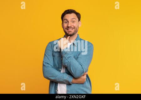 Smiling Man With Folded Arms Against A Yellow Background Stock Photo
