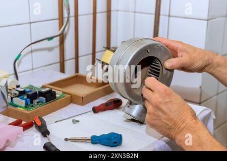 Technician maintenance with repair, cleaning of air turbine from dust for gas boiler Stock Photo