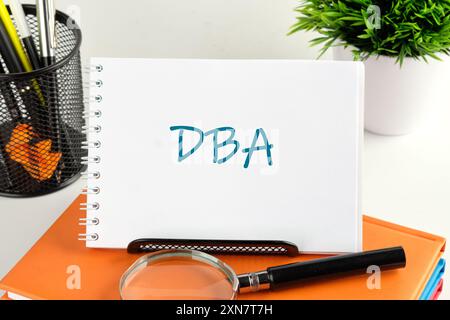 Business Term. Business Phrase DBA in a small notebook on a business book Stock Photo